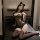 Woman wearing mist temptation lingerie set, a sheer one-piece sleepwear dress with lace trim and black stockings, posing sedu...