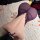 Woman wearing purple sheer lace bodycon sleepwear set on white rug with rose petals.