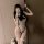 A woman poses with a teddy bear, wearing a white night-suit bodysuit featuring black accents, a sailor-style bow, and lace de...