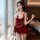 A woman poses elegantly in a luxurious red velvet lace sleep set, featuring delicate lace details and pearl accents, perfect ...