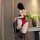 Woman in red lace bodysuit with open crotch, holding whip; black stockings and fluffy tail accent. nightsigh nightseduce set ...