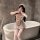 A woman poses playfully behind a bathtub wearing a charming maid costume. the outfit features ruffled details, a cute apron, ...