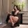 A woman poses elegantly in a black lace babydoll nightgown by nightsiyese, featuring a side slit and sheer design, paired wit...