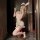 Woman in nightsiyese bunny costume with ears, gloves, and skirt posing for mirror selfie.