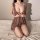 Woman kneeling on bed in plus size busty lingerie set with lace details and deep v-neck, sexy sleepwear for women.
