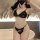 Woman wearing black lace bralette and thong set, bold and alluring plus size lingerie for women.