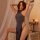 A woman poses elegantly in a stylish, form-fitting gray sleep dress with a high neckline and thigh-high slit, exuding sophist...