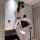 Woman modeling black plus size maid costume lingerie set with open-crotch design, white bows, and feather detail for adult ro...