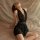 Woman wearing black deep v neck sleep dress with sheer mesh backless design, elegant plus size lingerie set for nightwear.