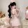 Woman modeling pink lace bunny girl costume with ruffled trim and sheer mesh details, featuring bunny ears headband and playf...