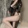 Woman wearing black lace sleepwear set with high slit, sheer mesh fabric, and provocative uniform-style design for plus size.