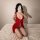 Woman modeling red sheer lace lingerie set on bed, showcasing plus size sexy sleepwear with delicate straps and sensual desig...