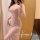 A woman poses in a sheer pink lace sleep dress featuring a side slit, exuding elegance and sensuality. perfect for loungewear...