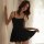 A woman poses elegantly in a black lace sleepwear set, featuring a sexy sheer babydoll nightgown with a backless design, perf...