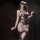 Woman wearing pure & playful lace lingerie set with pearl accents, bow detail, and matching bodysuit in purple and black.