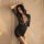 Woman wearing black lace lingerie set with deep v-neck and sheer sleeves, posing elegantly against soft beige backdrop.