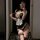 Woman in mirror selfie wearing pure & playful lingerie set – black satin dress with white lace apron, garter stockings, and b...