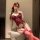 Woman wearing red lace bodysuit with padded bra, sheer corset top, and matching garter stockings for a seductive date night l...