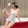 Woman in pure & seductive lace bodysuit, flirty sleepwear set with feather wand, elegant bedroom lingerie outfit.