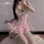 Woman in pink lace corset dress with fishbone bodice, ruffled hem, and white garter straps—soft, romantic lingerie for intima...