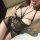 Woman wearing black sheer mesh bodycon skirt and matching bralette from pure & seductive lingerie set, featuring strappy desi...