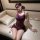 Woman wearing purple pure & seductive lingerie set with lace trim, open-crotch bodycon skirt, and matching blindfold on sofa.