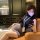 Woman in pure & seductive secretary-style bodycon lingerie set, posing confidently on leather couch with phone and id badge.