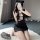 A woman poses in a black lace nightgown inspired by traditional chinese qipao, featuring deep plunging necklines and playful ...
