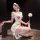 Woman in white pure temptation nurse costume lingerie set with red cross, blindfold, and feather duster posing seductively.