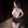 Woman wearing pure & tempting lace bodysuit with sheer mesh, flirty cutouts, and matching garter stockings.