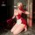 Woman kneeling in red lace lingerie set with sheer mesh panels, white apron, and long gloves holding a phone.