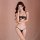 Woman modeling qiao hu niang black lace lingerie set with sheer bra and open-crotch panty against pink background.
