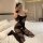 Woman wearing qingran sexy secretary lingerie set – sheer black bodysuit with open-crotch design, posing on bed.