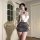 Woman in qingshe ol secretary lingerie set with lace bra, gray mini skirt, and blindfold, posing elegantly indoors.