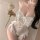 Woman in white sheer lace rabbit girl costume with push-up cups, open crotch, and rose.