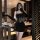 A woman poses in a luxurious bathroom, wearing a black velvet lace bodycon mini dress. the sheer design features thin straps ...