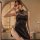 Woman wearing black retro chinese cheongsam lingerie with side slit and adjustable bondage straps for role play.