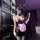 Woman in black bunny lingerie set with ears, mask, and apron holding whip.