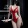 Woman wearing red lace bodysuit with cut-out details in modern bathroom setting.