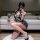 Woman posing in seductive lace lingerie set, a high-slit backless cheongsam dress with halter neck design.
