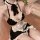Woman wearing black and white seductive maid costume lingerie set with ruffles, bow tie, and satin apron.