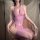 Woman wearing a seductive purple fishnet bodystocking with sheer mesh, featuring a halter neckline and cut-out details.