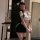 Woman in seductive secretary-style lingerie set with white top, black skirt, and cat ears, posing for a selfie.