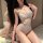 Woman wearing a sensual white lace bodysuit with cutouts and delicate straps, posing in front of a mirror.