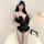 Woman modeling black sensual lace open-crotch bodysuit, a sheer sleepwear set with delicate floral patterns and feather accen...