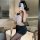 Woman wearing black lace sleepwear set with sheer top and shorts, posing in modern bathroom for romantic date night look.