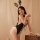 Woman wearing black sheer bunny girl bodysuit with straps, open-crotch design, lace trim, and matching ears — sexy lingerie s...