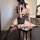 Woman wearing black lace bodysuit with bunny mask, seated on patterned stool — provocative plus size sleepwear for small bust...