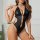 Sexy leather bodysuit featuring halter neck design, patent shine, and heart embellishments for an elegant look.