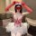 Woman wearing a sexy nurse costume with lace details, red gloves, and a white tutu for halloween or cosplay.